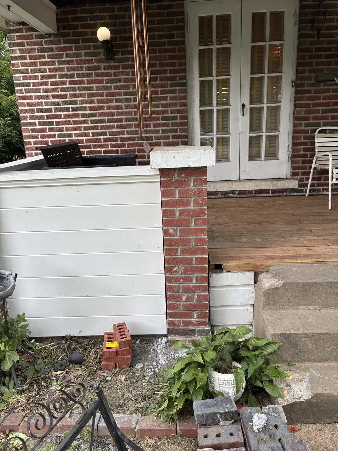 White porch panels and trim beside brick columns